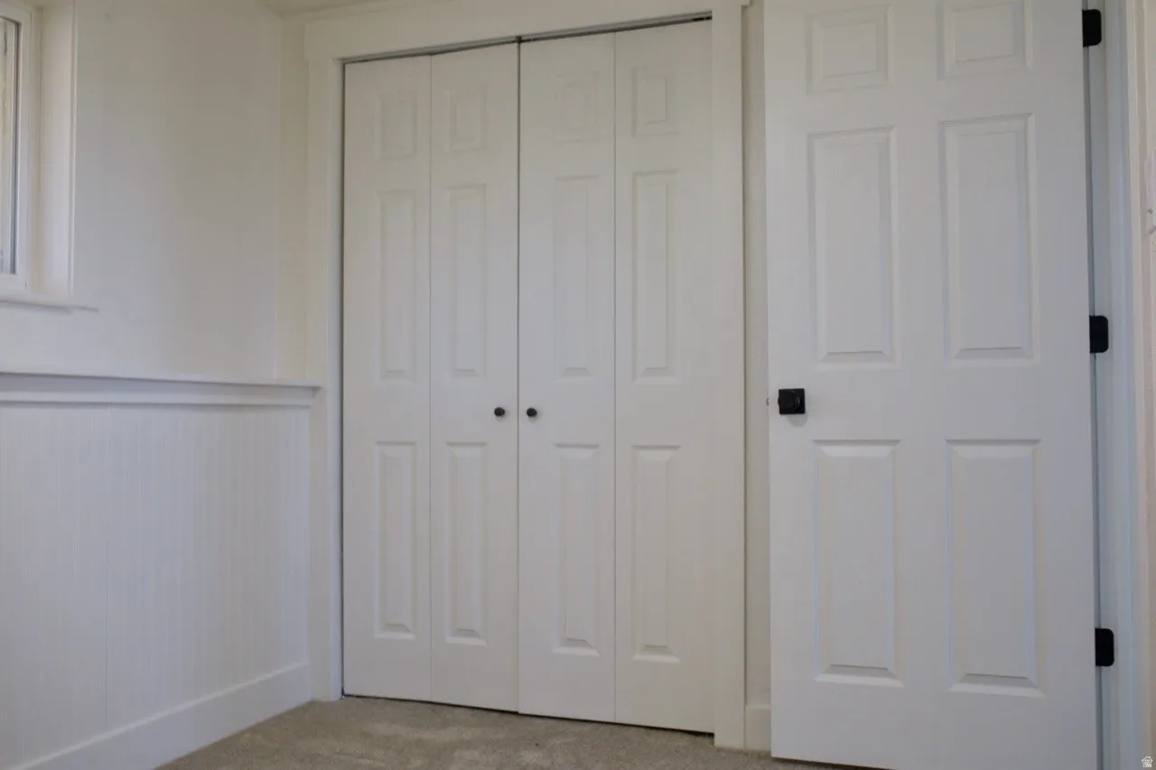White paneled bifold closet doors with dark hardware
