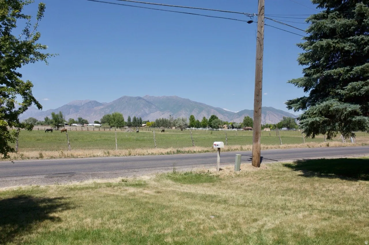 Expansive mountain backdrop with distant green fields and scattered trees
