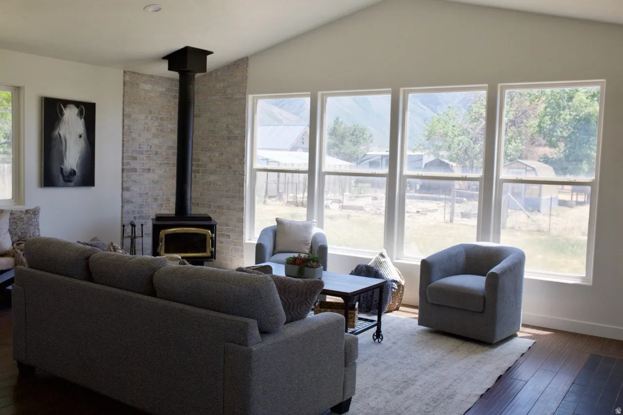 Living area featuring a vaulted ceiling and dark wood-finish flooring