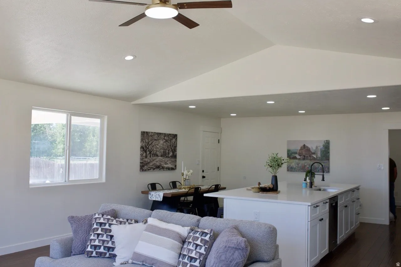 Spacious living area featuring a vaulted ceiling with recessed lighting and a ceiling fan
