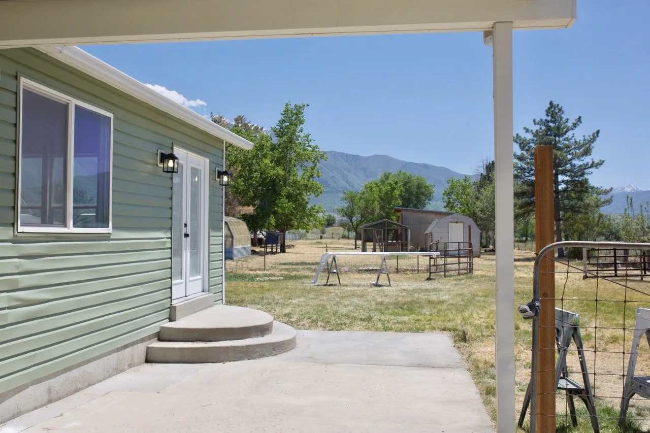 Exterior featuring light green horizontal siding and a white trim