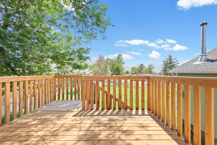 Expansive wooden deck with natural wood railing overlooking a grassy yard