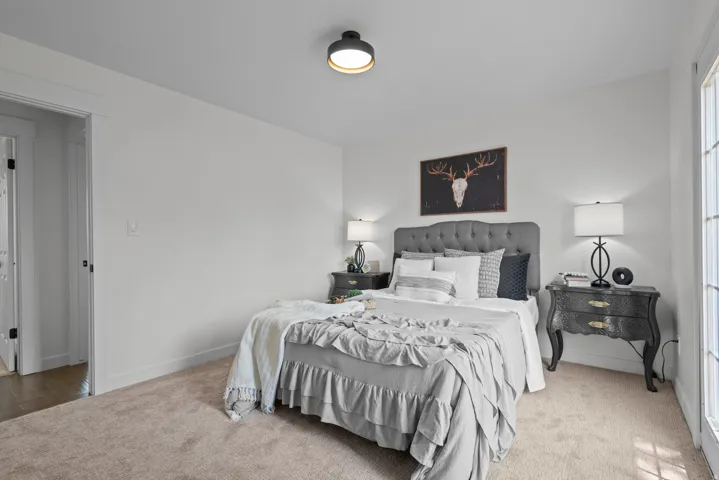 Carpeted flooring, recessed lighting, and a tufted headboard