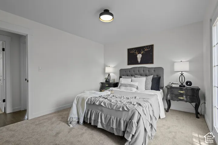 Carpeted flooring, recessed lighting, and a tufted headboard
