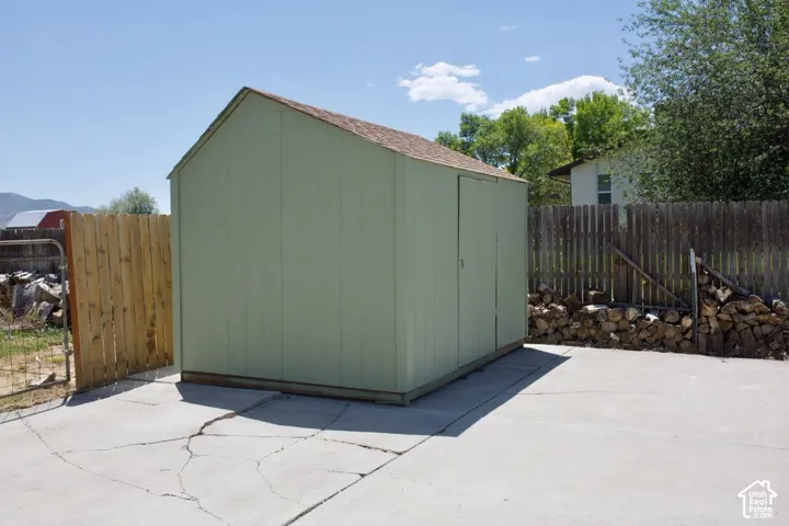 Gable-roof storage shed with a panel siding exterior and shingle roofing