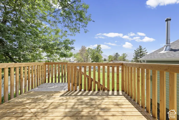 Expansive wooden deck with natural wood railing overlooking a grassy yard