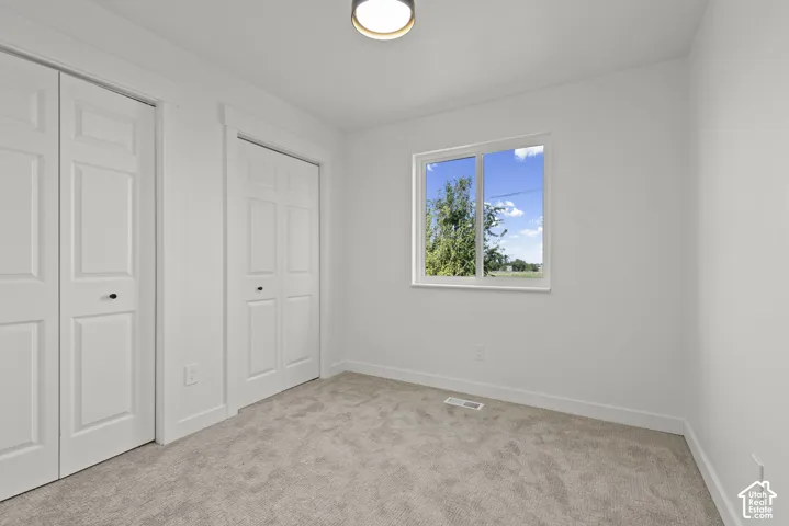 Light-toned carpeted flooring complements bright white walls