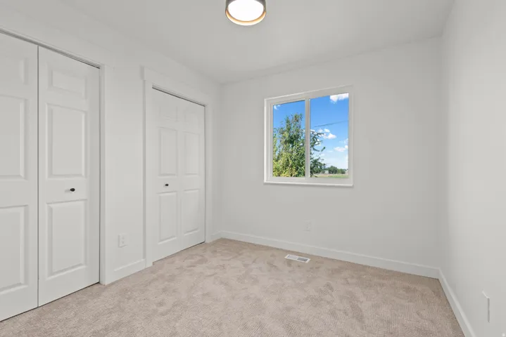 Light-toned carpeted flooring complements bright white walls