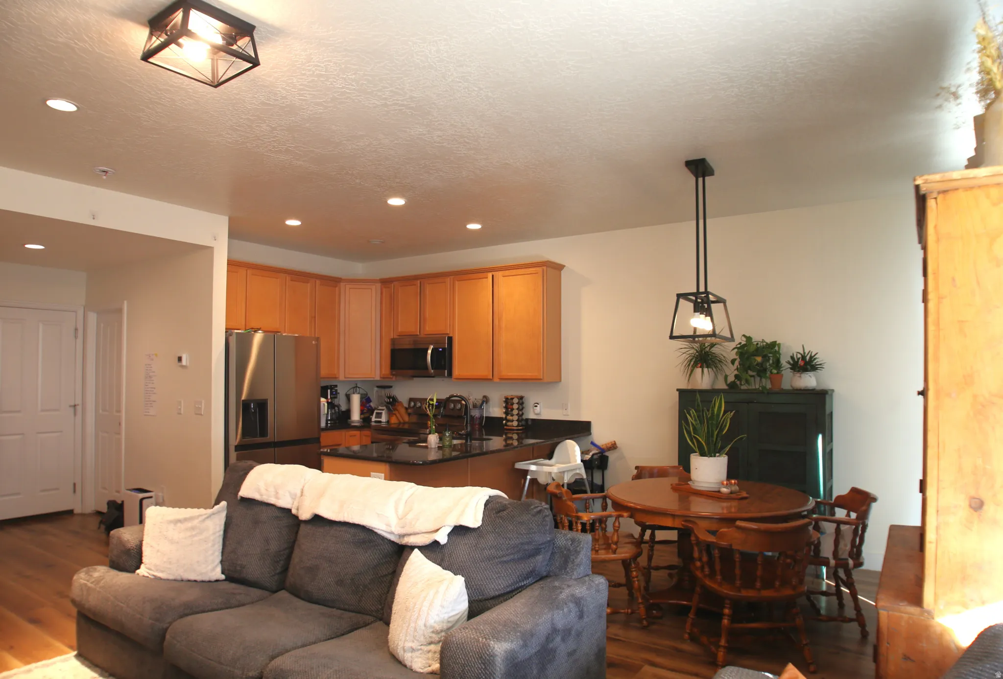 Open-concept living space featuring wood-finish flooring, recessed lighting, and a modern kitchen