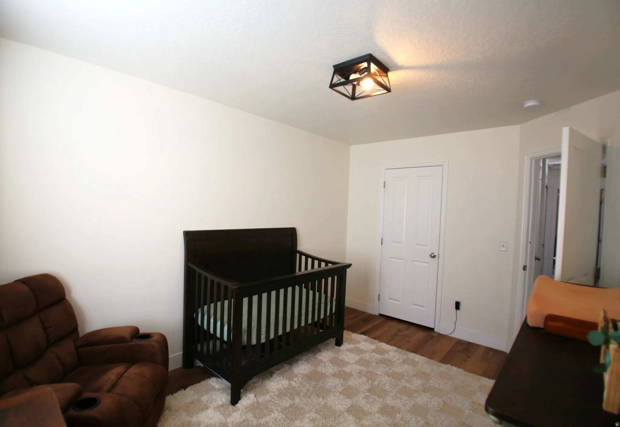Room featuring light-toned walls and wood-finish flooring
