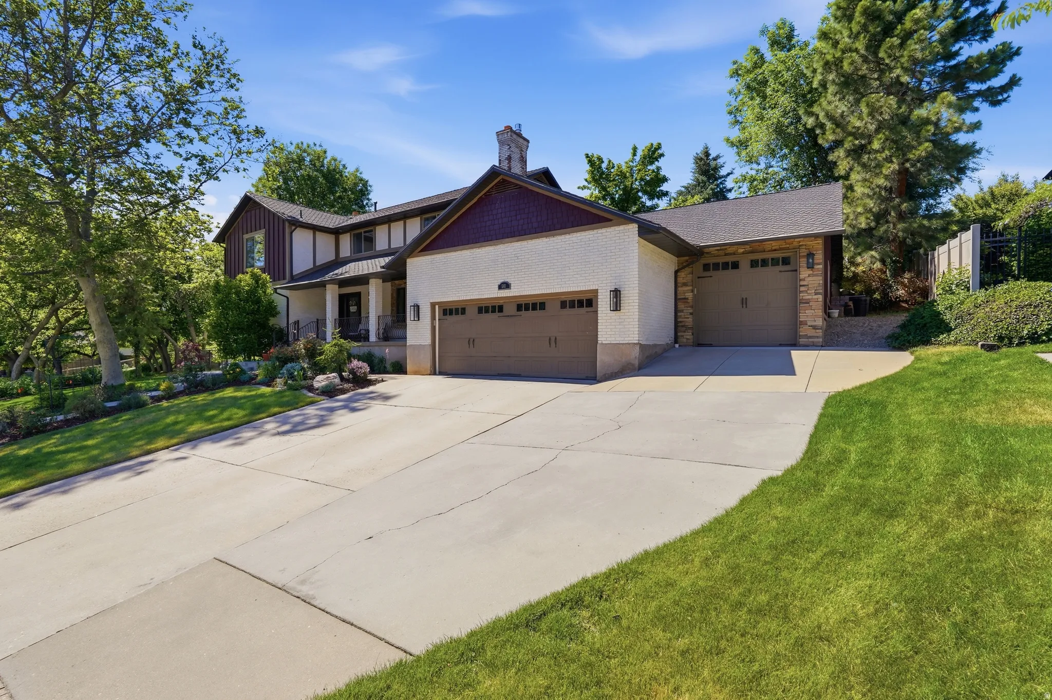 Expansive concrete driveway leading to a multi-car garage with two separate doors