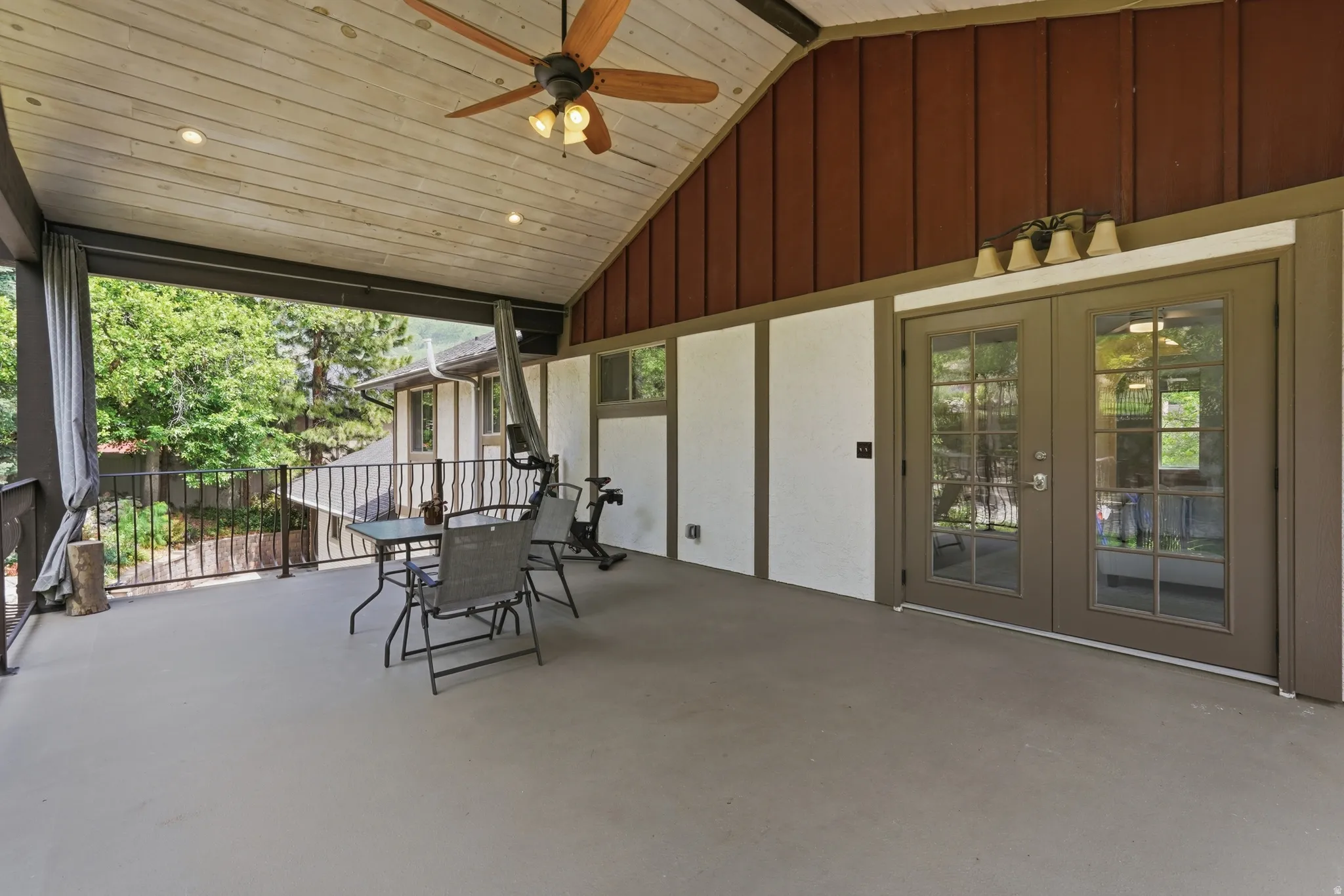 Covered outdoor deck with a vaulted wood-finish ceiling, recessed lighting, and a ceiling fan