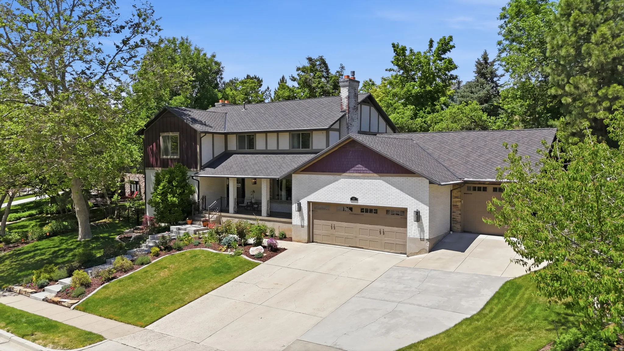 Expansive property featuring a multi-level architectural style, a covered front porch, and a paved driveway