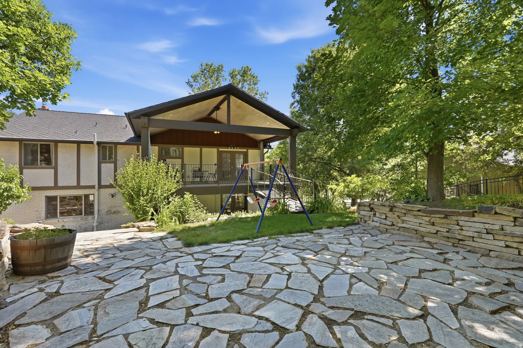 Expansive flagstone patio with a stone retaining wall
