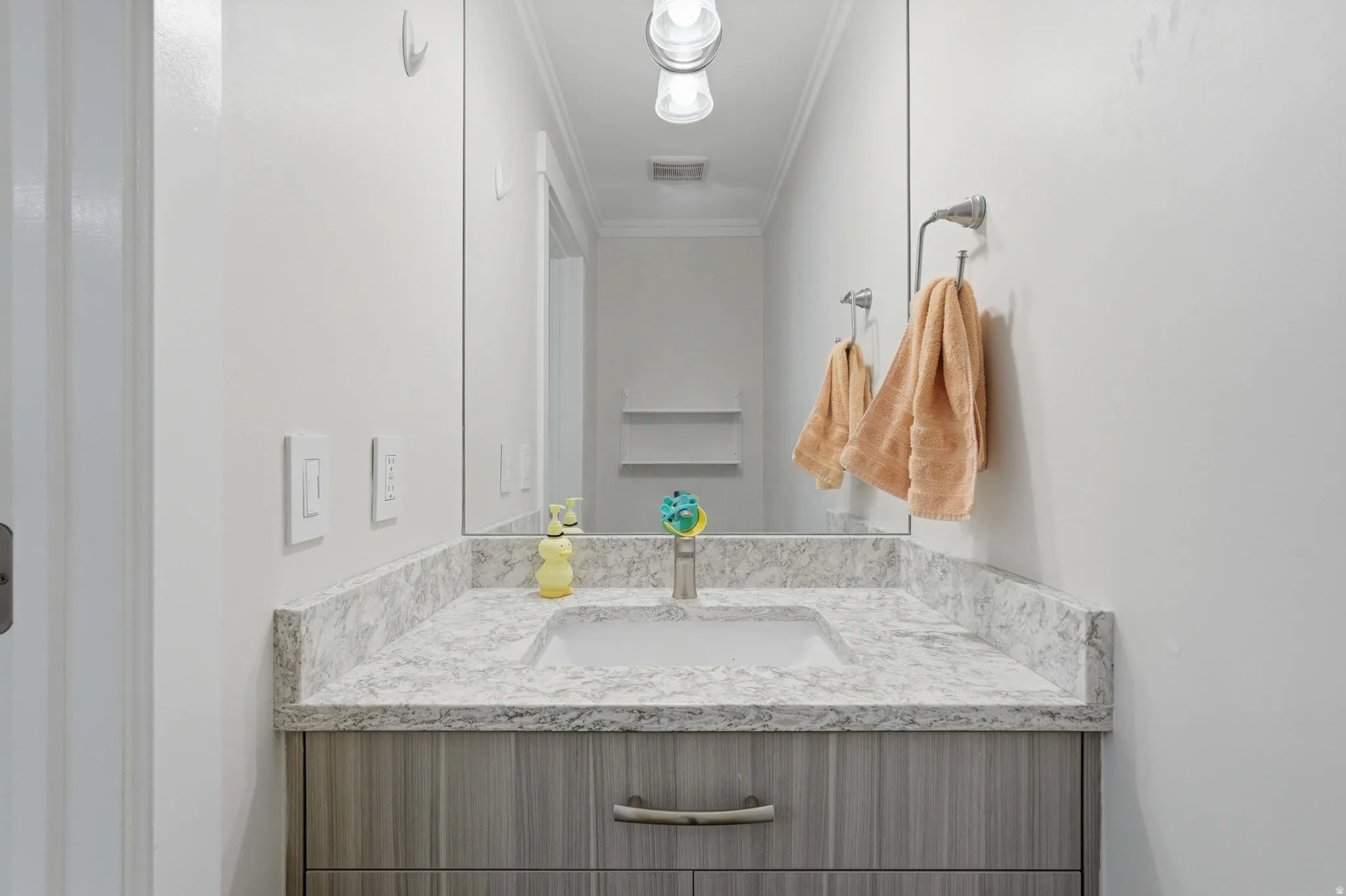 Modern vanity with a light wood-grain finish and brushed nickel hardware