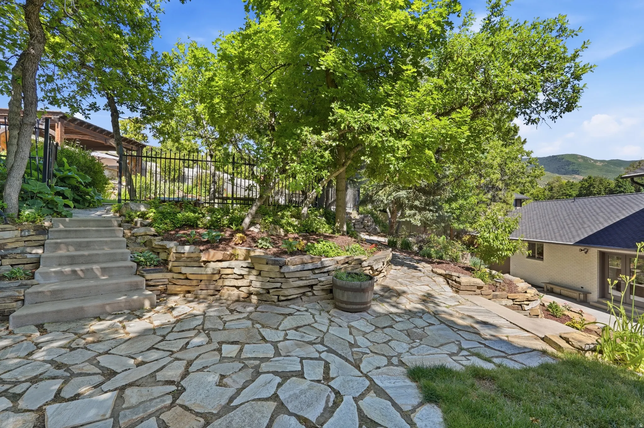 Expansive flagstone patio with concrete stairs and natural stone retaining walls