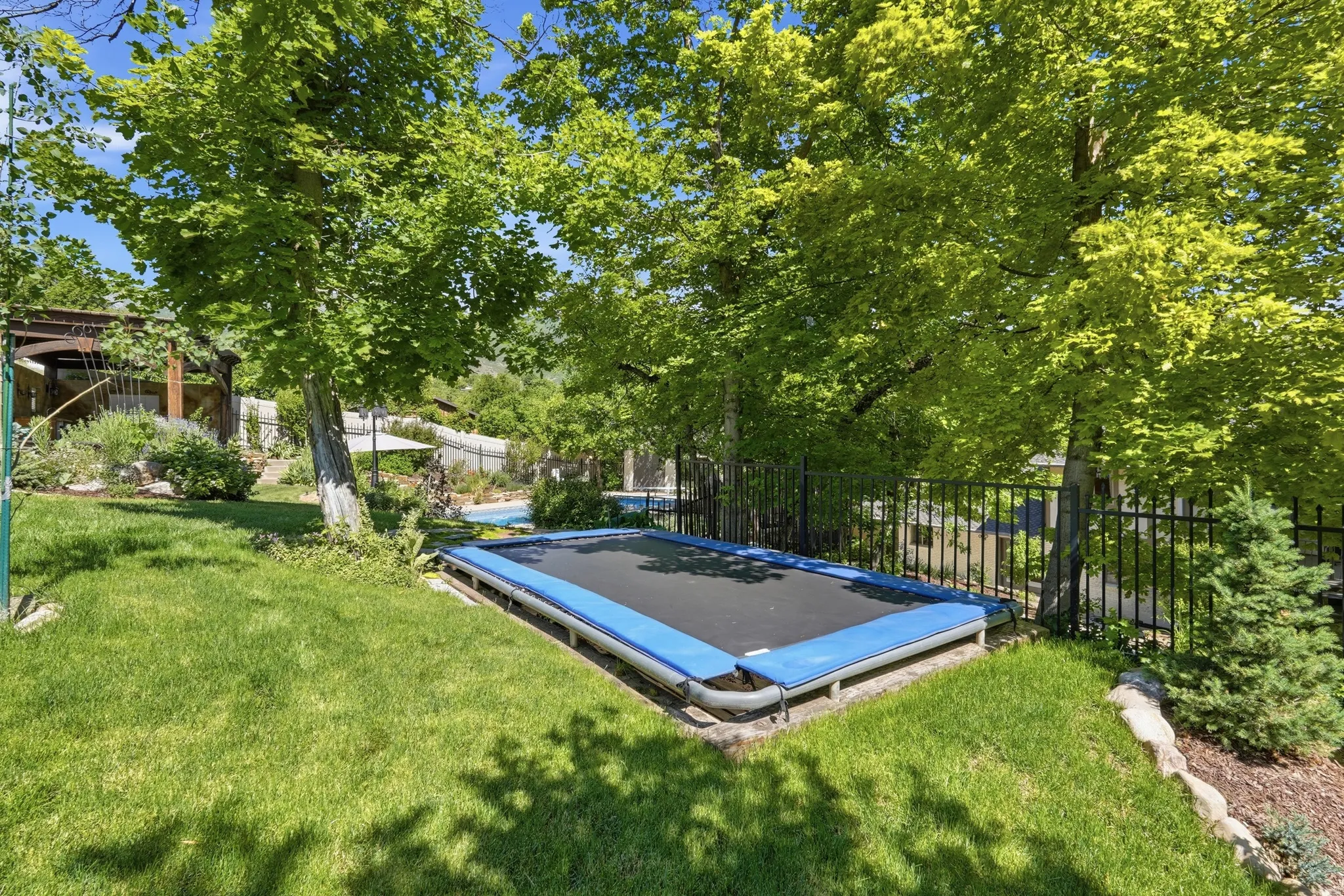 Expansive green lawn featuring mature trees providing ample shade