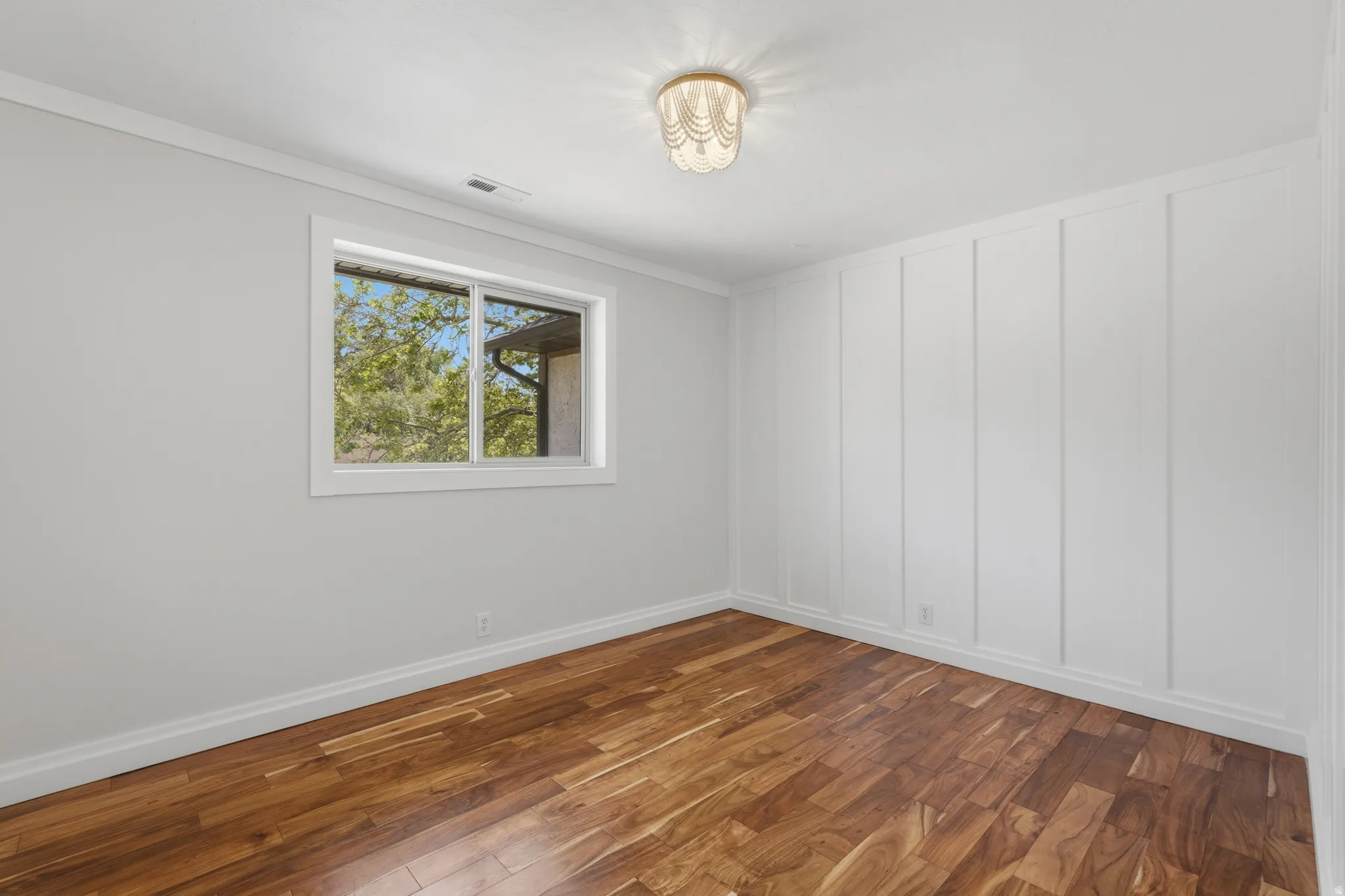 Warm wood-finish flooring complements the crisp white board and batten accent wall
