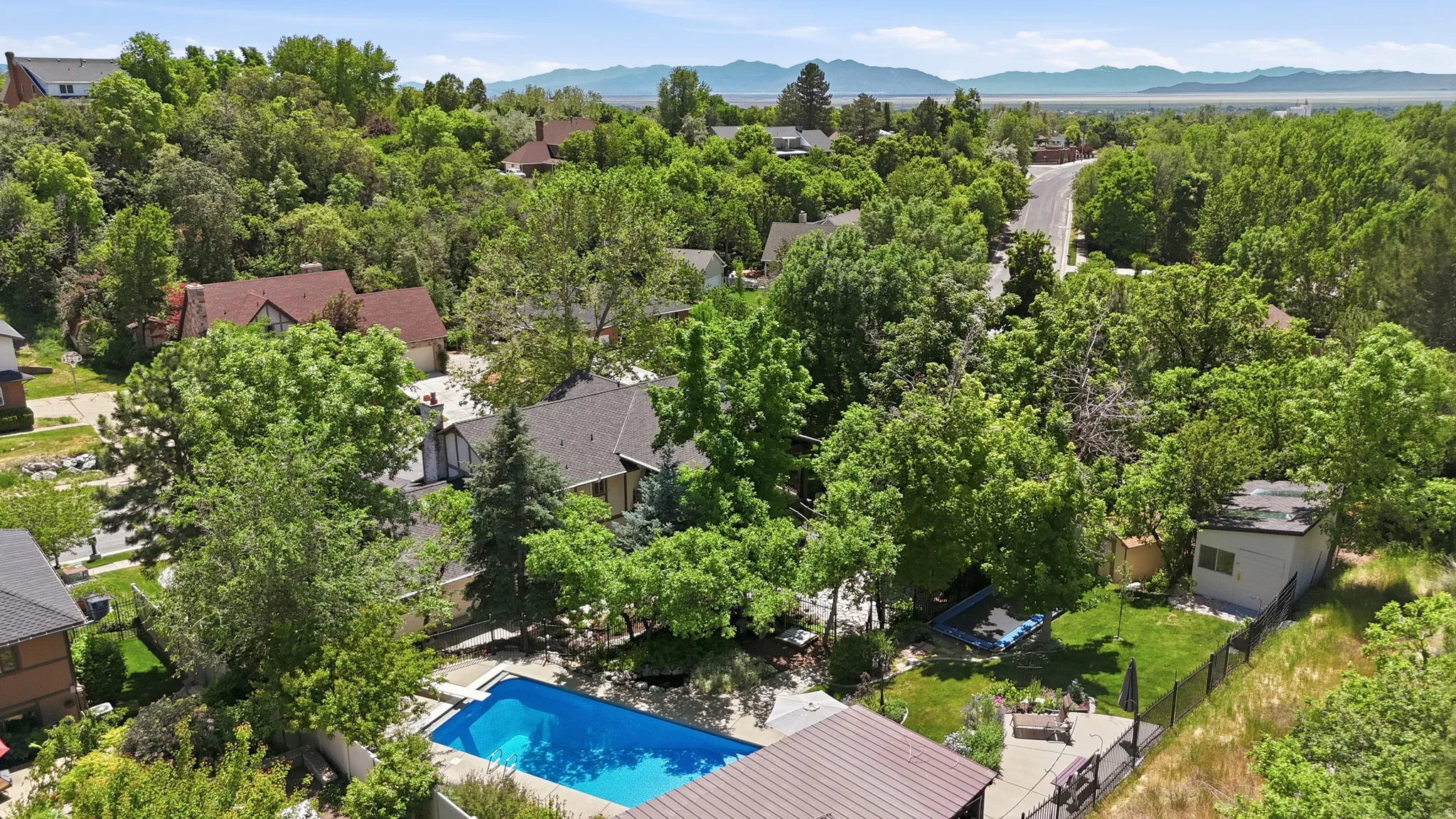 Outdoor swimming pool with surrounding patio space, fenced backyard, and a detached shed