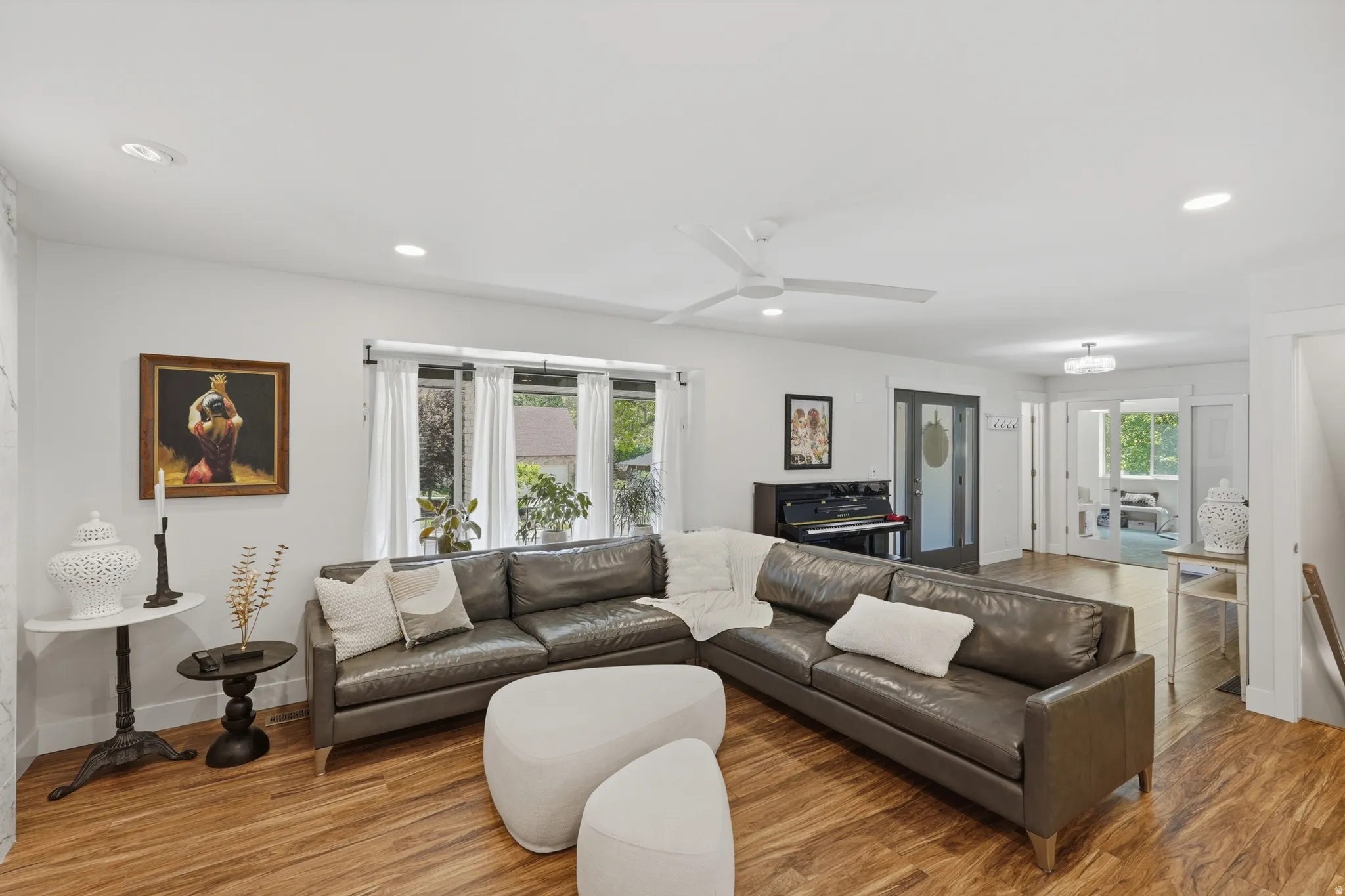 Spacious living area featuring wood-finish flooring, recessed lighting, and a modern ceiling fan