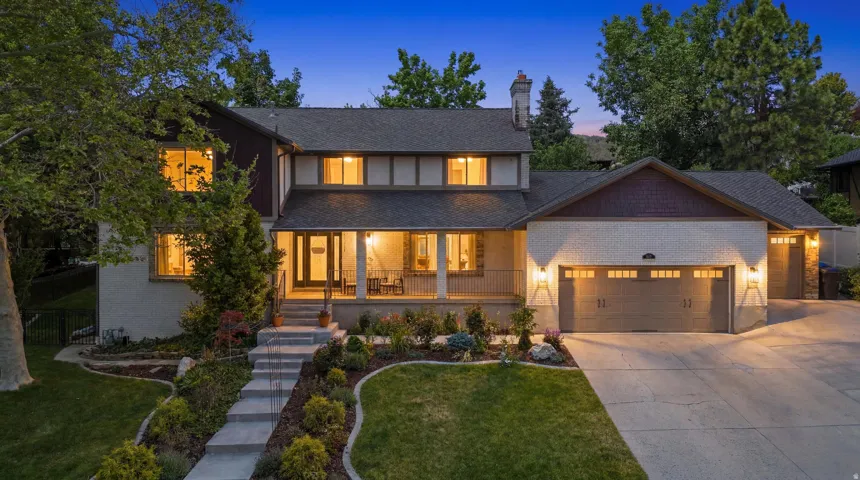 Two-story residence featuring a covered front porch, a three-car garage, and a brick and siding exterior