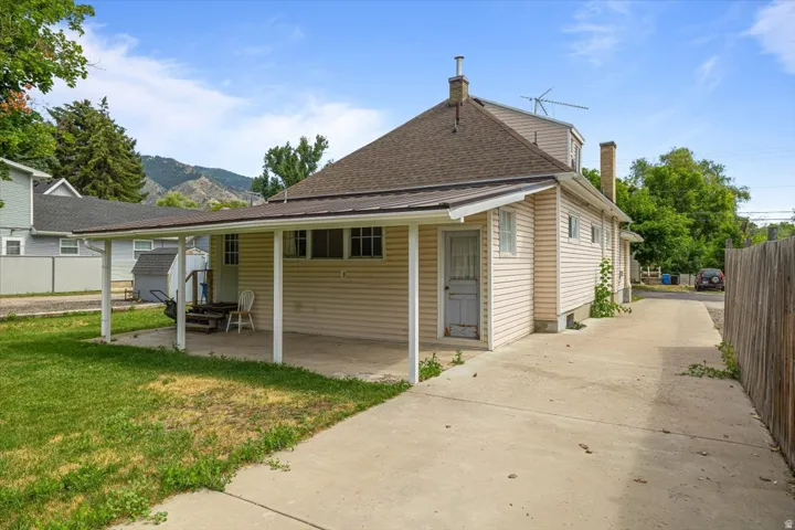 Side exterior featuring a covered patio, concrete driveway, horizontal siding, and a gabled roof