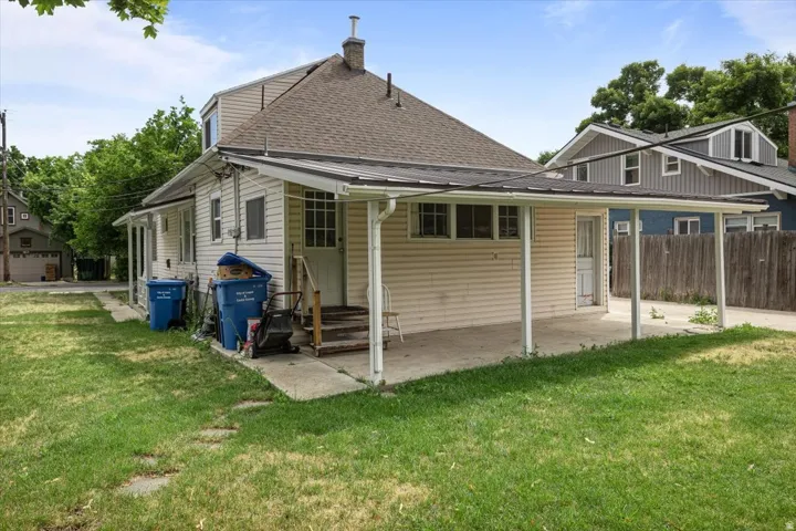 Rear exterior with a covered patio, concrete slab, and wood privacy fencing