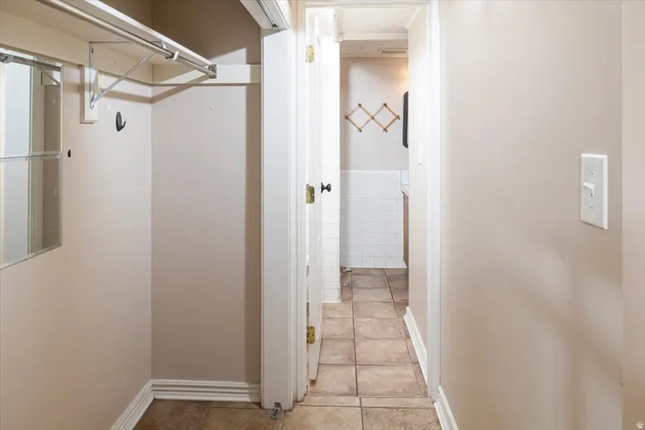 Walk-in closet with built-in shelving, hanging rod, and mirror panel