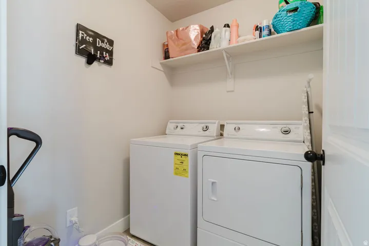 Dedicated laundry space featuring a white shelf for storage