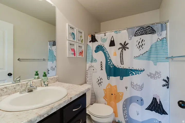 Bathroom featuring a vanity with a light-colored countertop, an undermount sink, and a chrome faucet