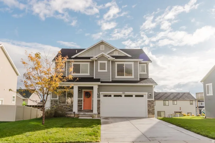 Two-story residence featuring gray siding, white trim, and a prominent front-facing garage