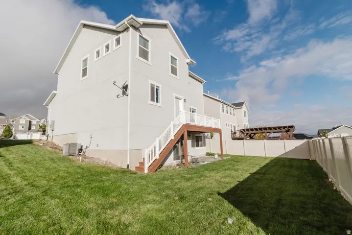 Rear exterior featuring a deck with white railings and brown stairs