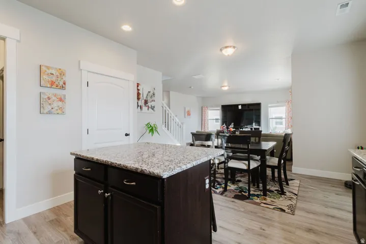 Kitchen island with a light-toned countertop and dark wood-finish cabinetry