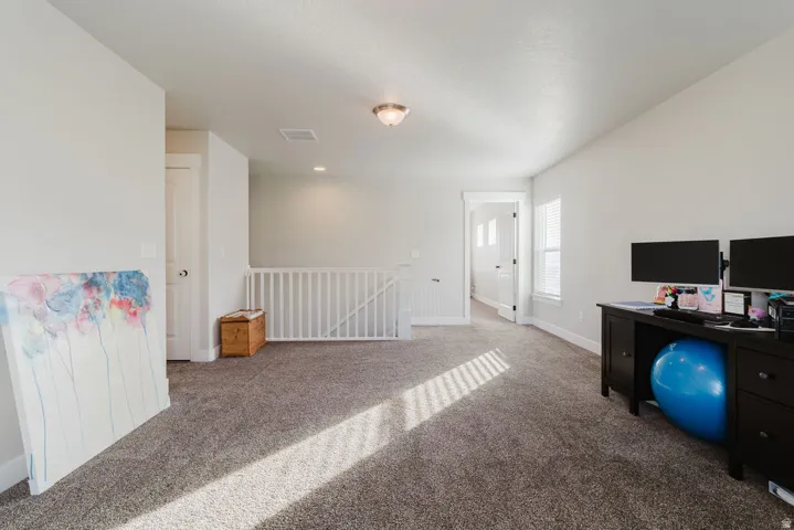 Carpeted open loft area featuring a white baluster railing, recessed lighting, and a semi-flush mount ceiling fixture