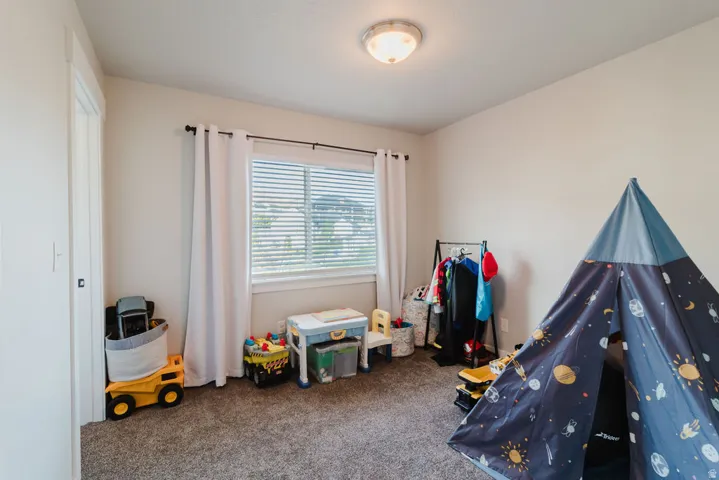 Carpeted interior room with neutral wall paint and a single window