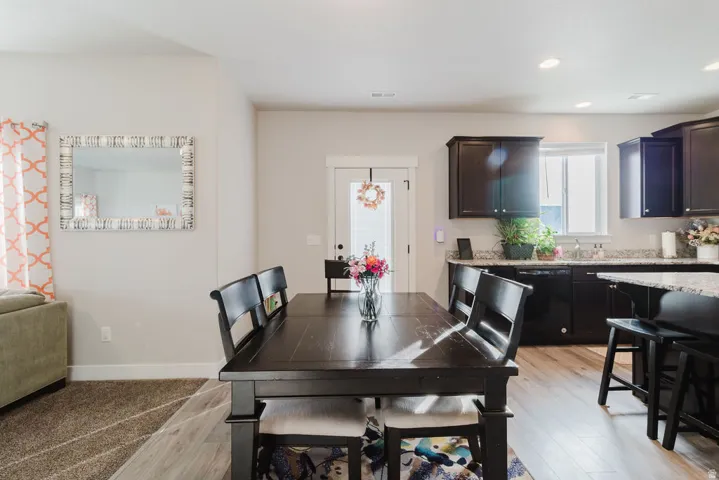 Open-concept dining area featuring a wood-finish dining table and light wood-finish flooring