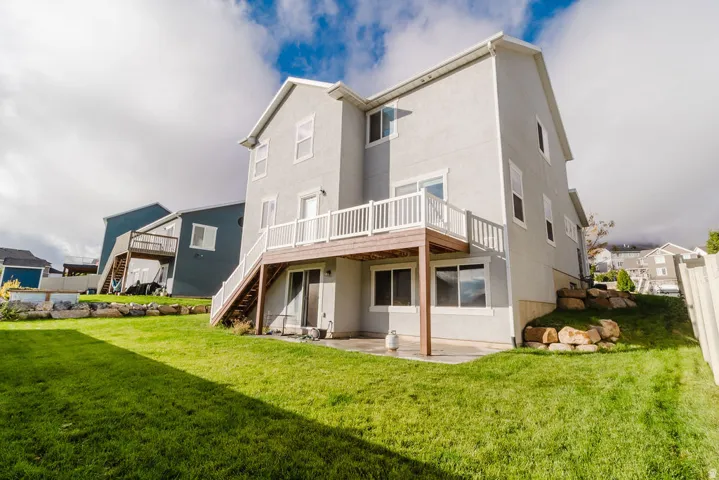 Rear exterior featuring a multi-level structure with a stucco finish and white trim