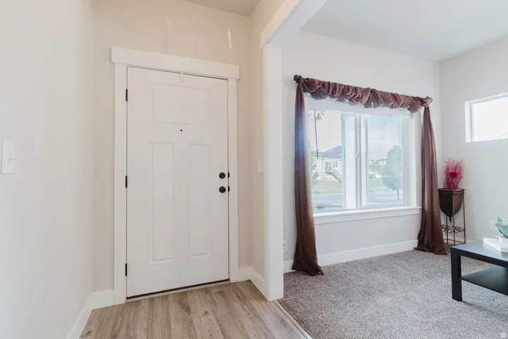 Entryway featuring wood-finish flooring and a white paneled door with black hardware