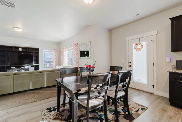 Open-concept living space featuring wood-finish flooring, recessed lighting, and a built-in media center
