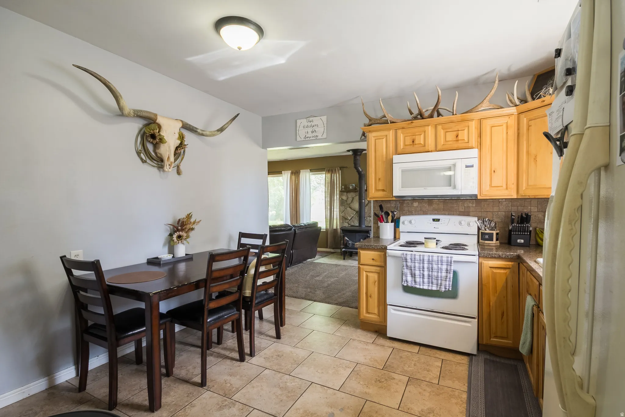 Kitchen featuring wood cabinetry, white appliances, and a tiled backsplash