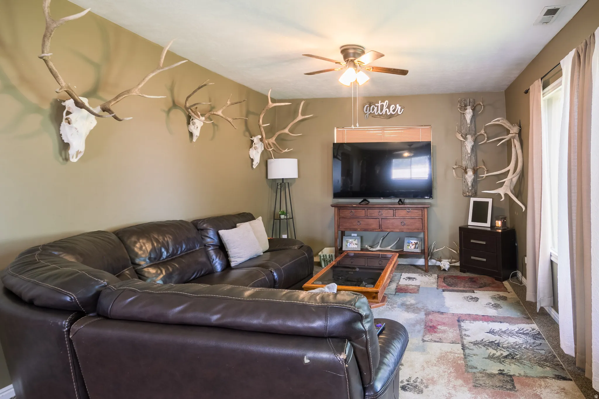 Spacious interior with neutral wall paint and a ceiling fan