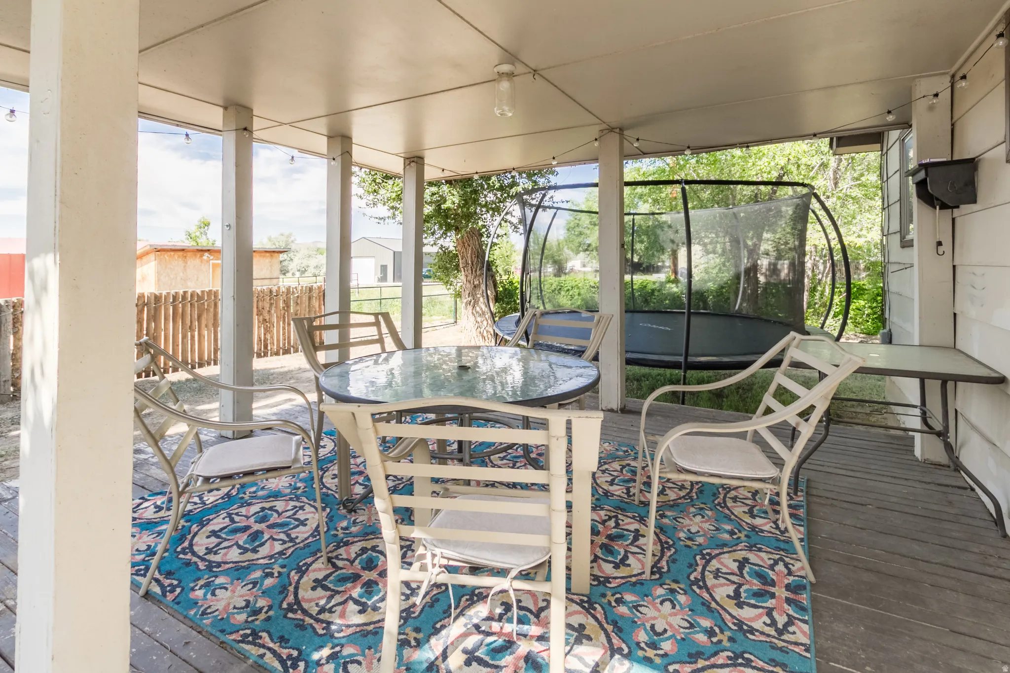 Covered patio with wood-finish decking, supported by multiple columns