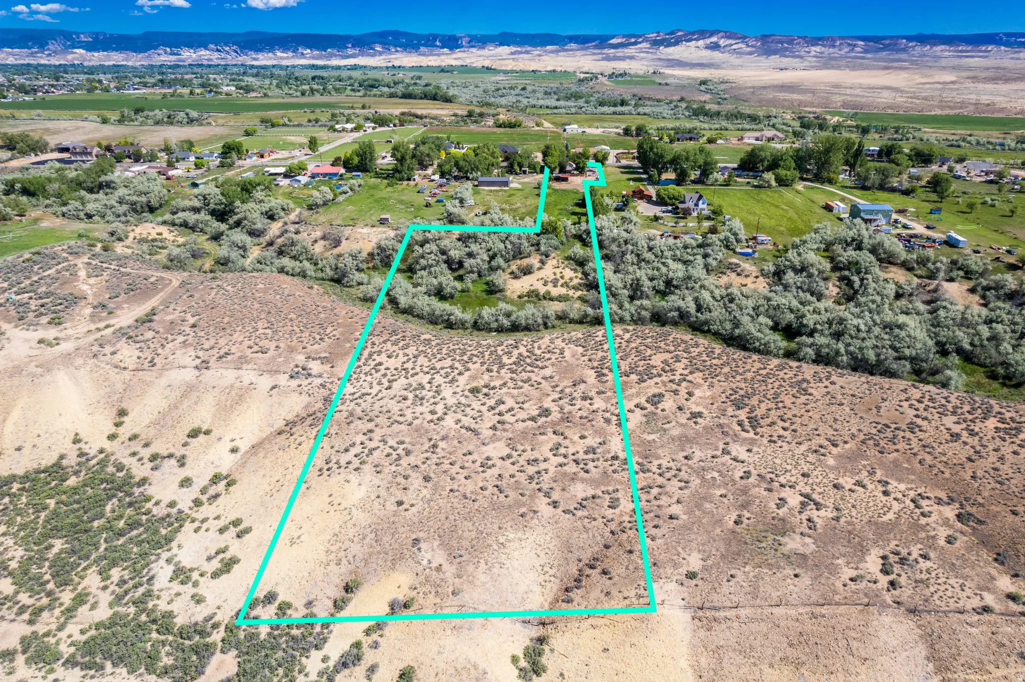 Expansive land parcel featuring natural shrubbery and varied topography, outlined by a clear boundary