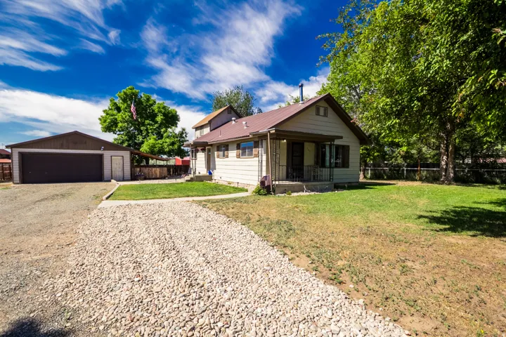 Single-story residence with a metal roof and a covered front porch featuring wrought iron railings