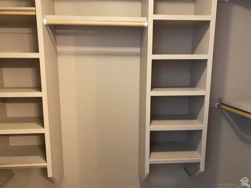 Primary Closet: Custom Integrated shelving system featuring multiple storage compartments and hanging rods
