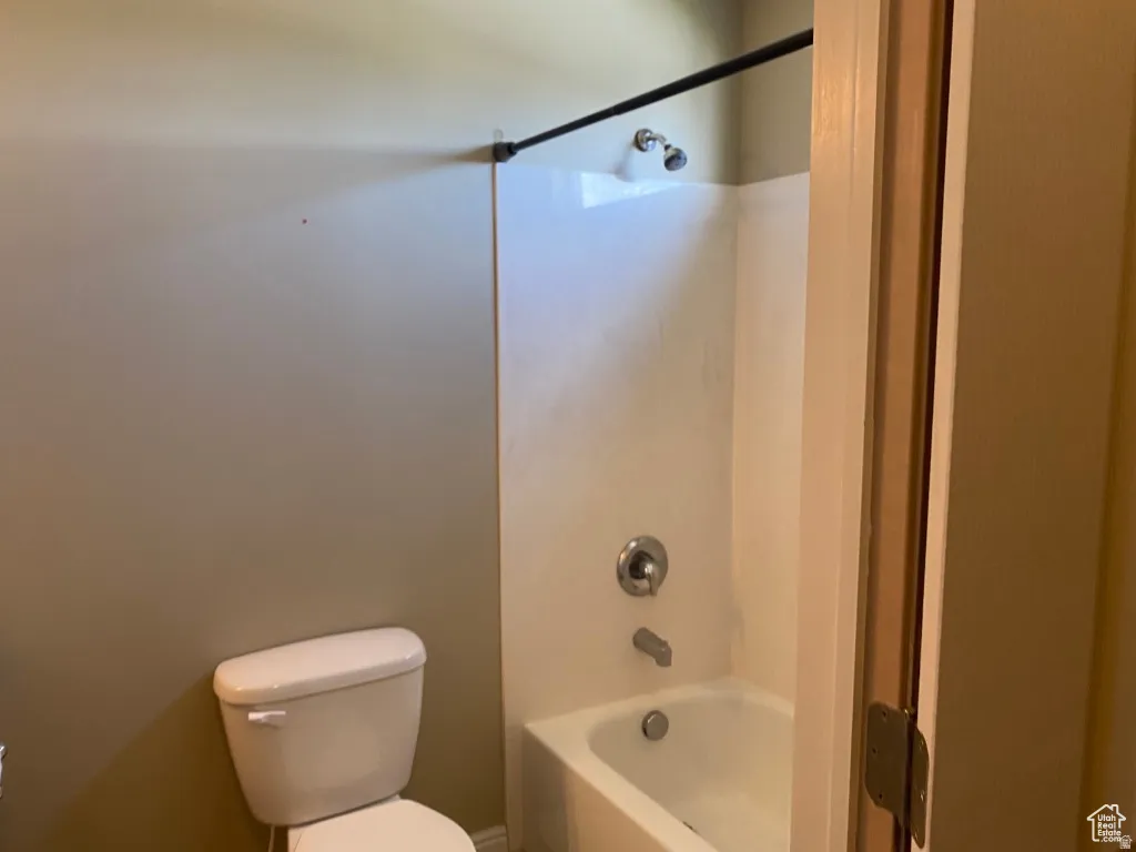 2nd Full Bath: White tub and shower combination with a curved shower curtain rod and chrome fixtures