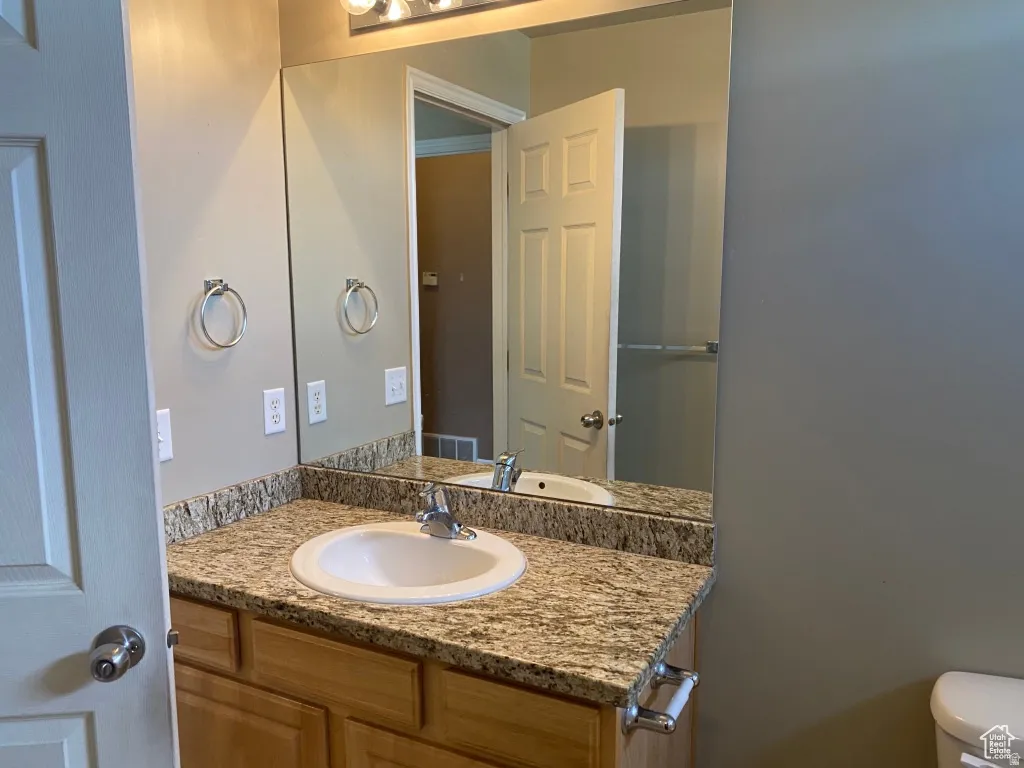 Primary Bathroom vanity featuring a light-toned countertop, undermount sink, and light wood cabinetry