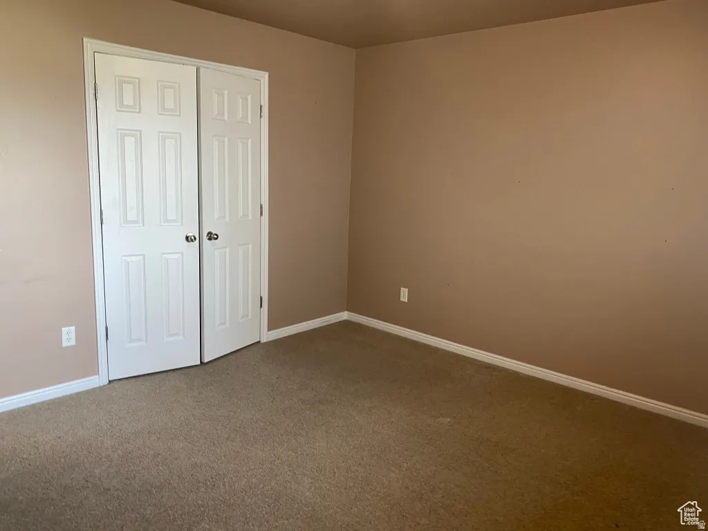 Bedroom 2: Beige carpet flooring and neutral painted walls