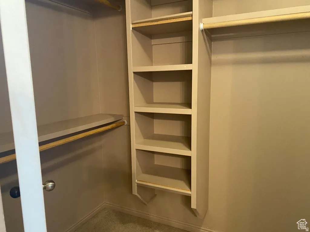 Primary Closet: Custom Built-in shelving unit providing five levels of storage, complemented by a hanging rod and a high shelf