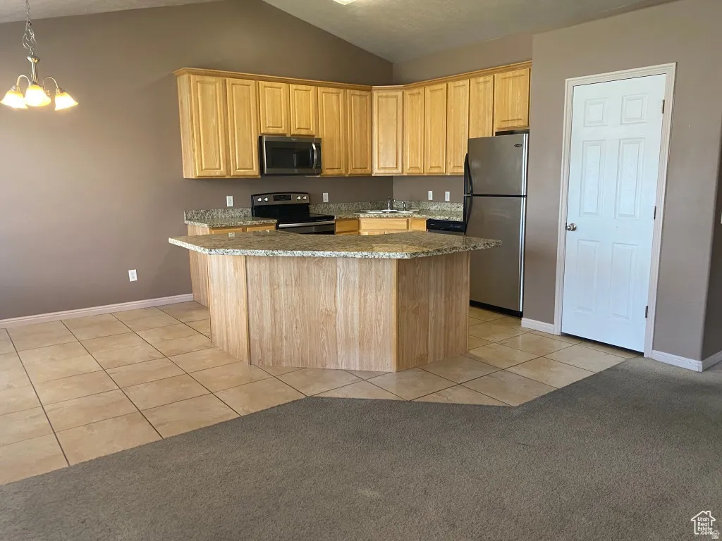 Kitchen featuring wood-finish cabinetry, stainless steel appliances, and granite countertops